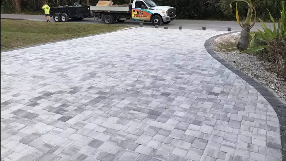 Completed gray concrete paver driveway with a charcoal border at a home in Venice, Florida