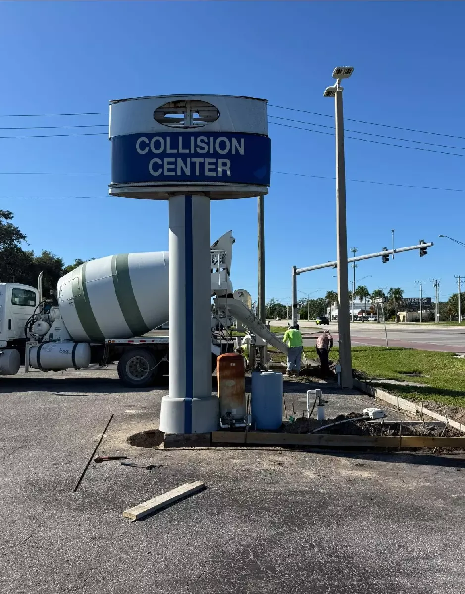 Concrete footing and curb installation behind a commercial sign base in Nokomis, Florida