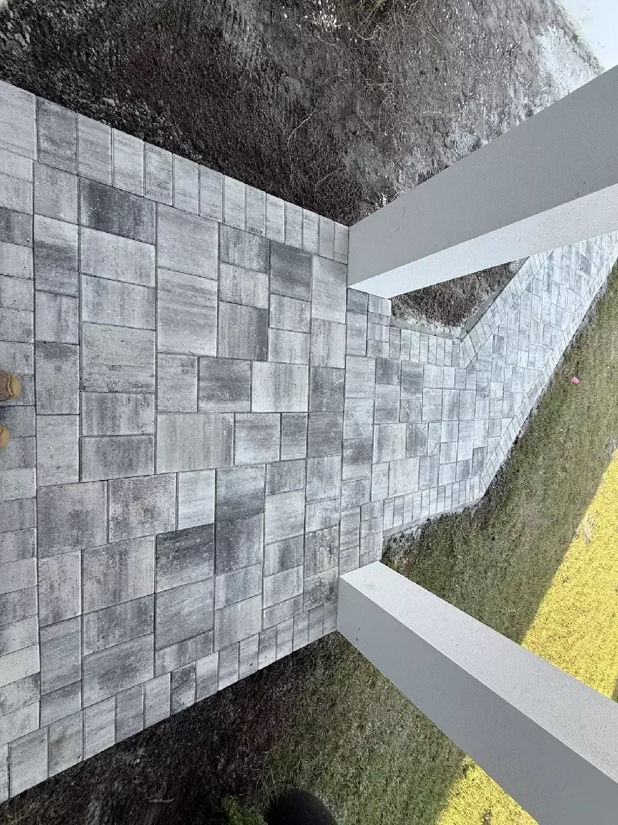 Concrete paver front entrance with a curved dark border at a Nokomis, Florida home