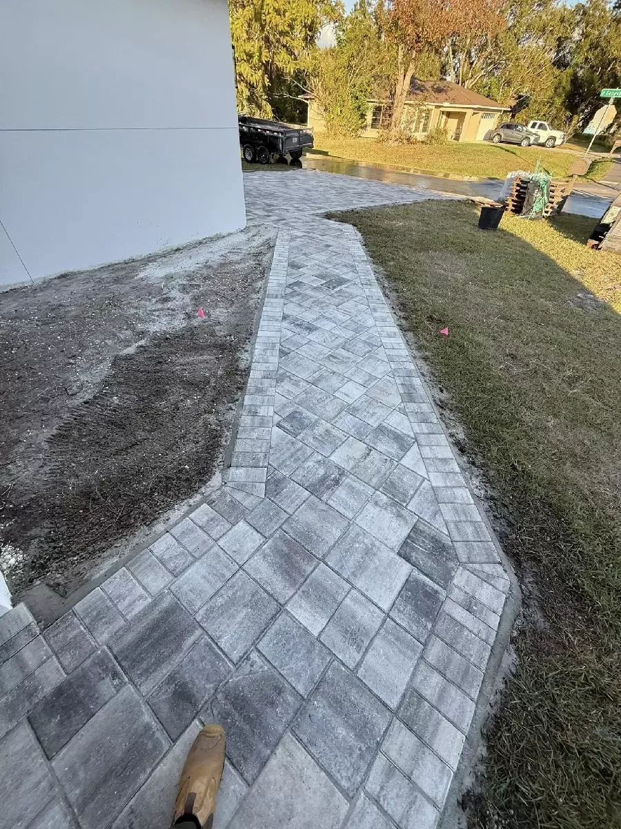 Gray concrete paver walkway running along the side of a Nokomis, Florida property