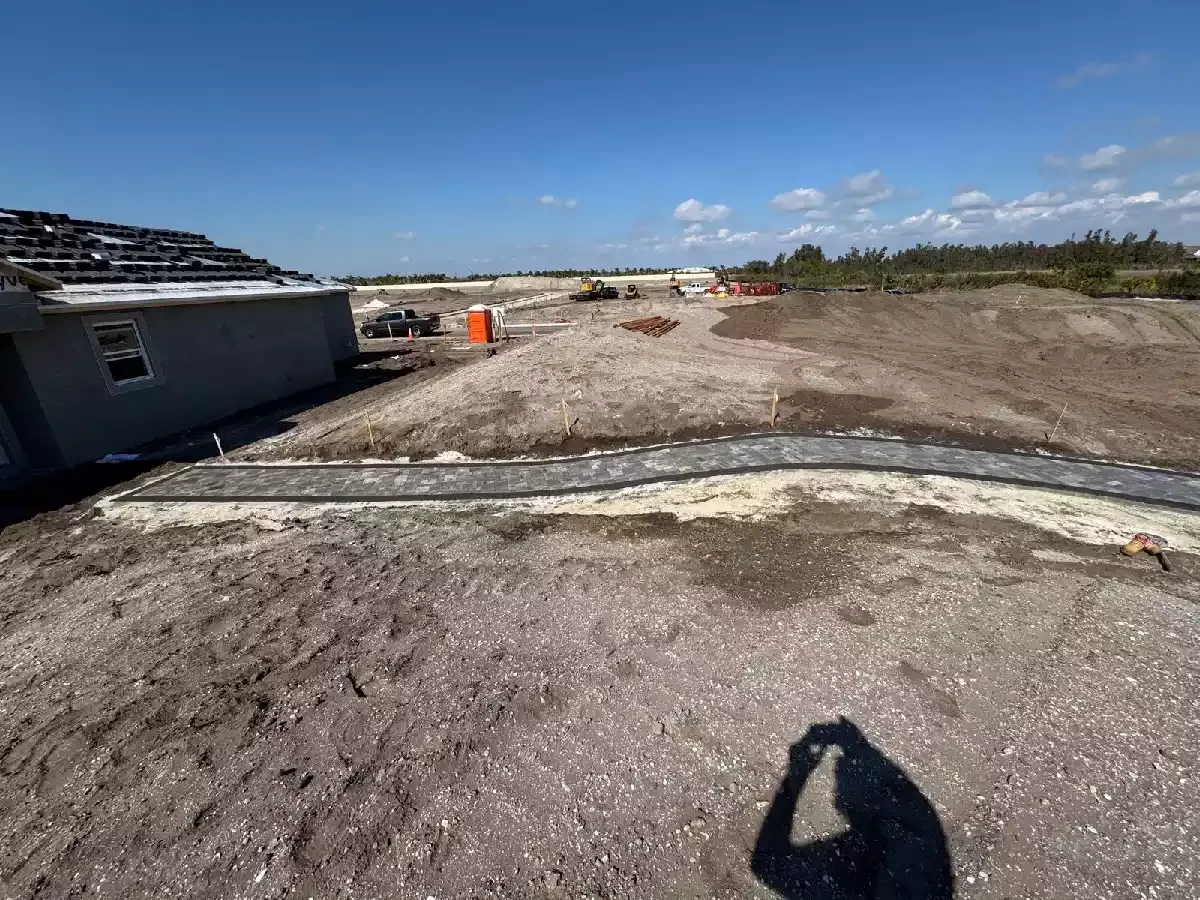 Wide concrete paver pathway connecting buildings at a North Port, Florida development
