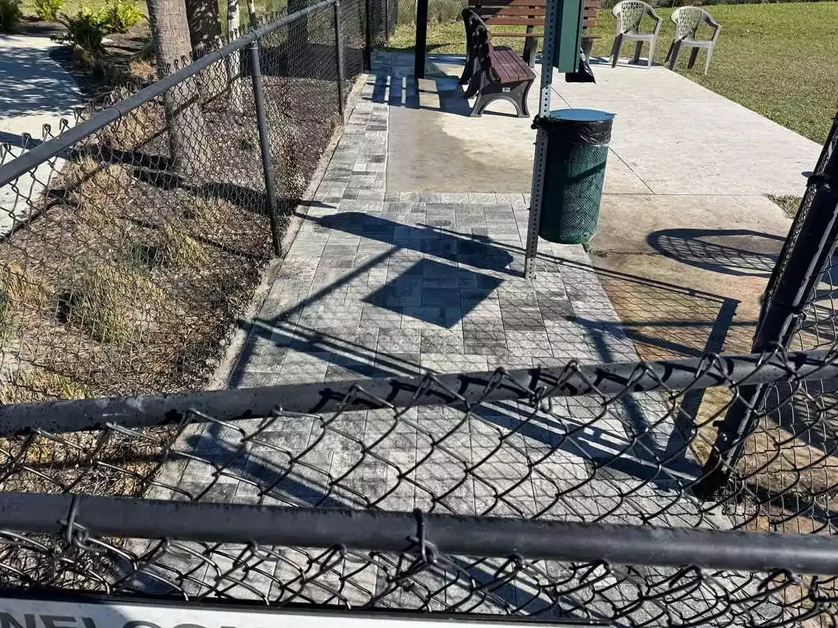 Paver seating area with shade structures at a commercial dog park in Osprey, Florida