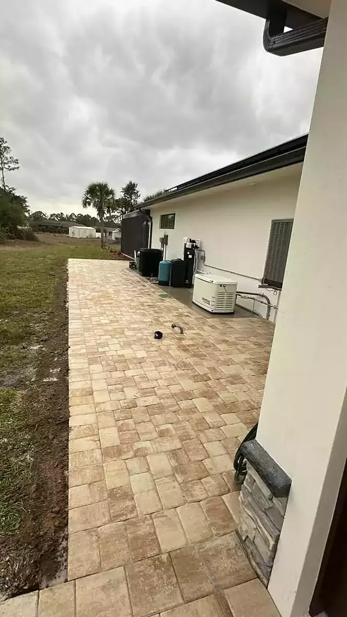 Beige brick paver patio running along the side of a home in Venice, Florida