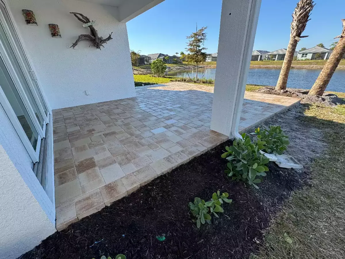 Beige travertine paver patio along the side of a residential home in Venice, Florida
