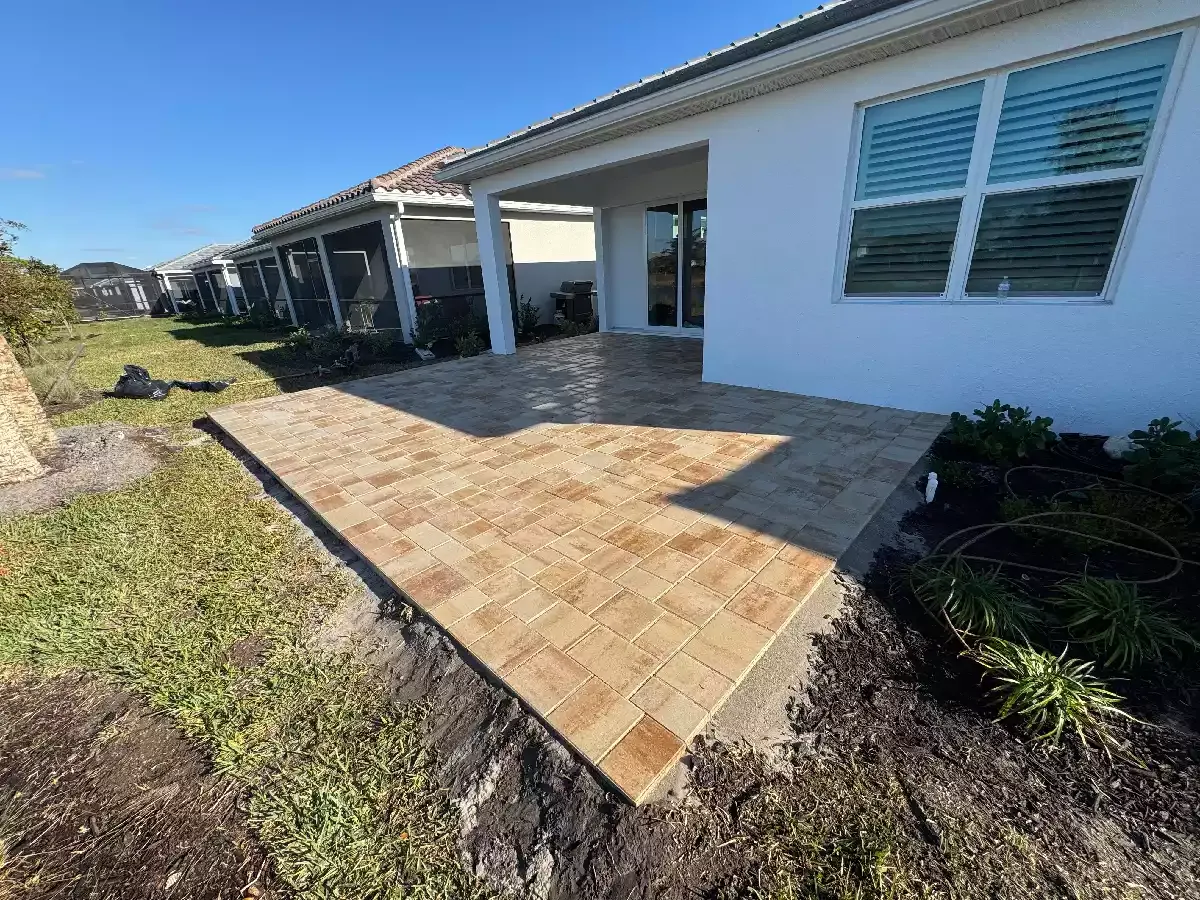 Rectangular travertine paver patio behind a residential home in Venice, Florida