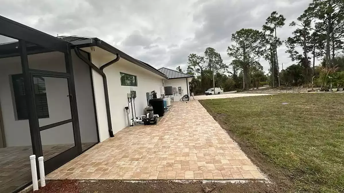 Tan concrete paver patio extension along the side of a home in Venice, Florida