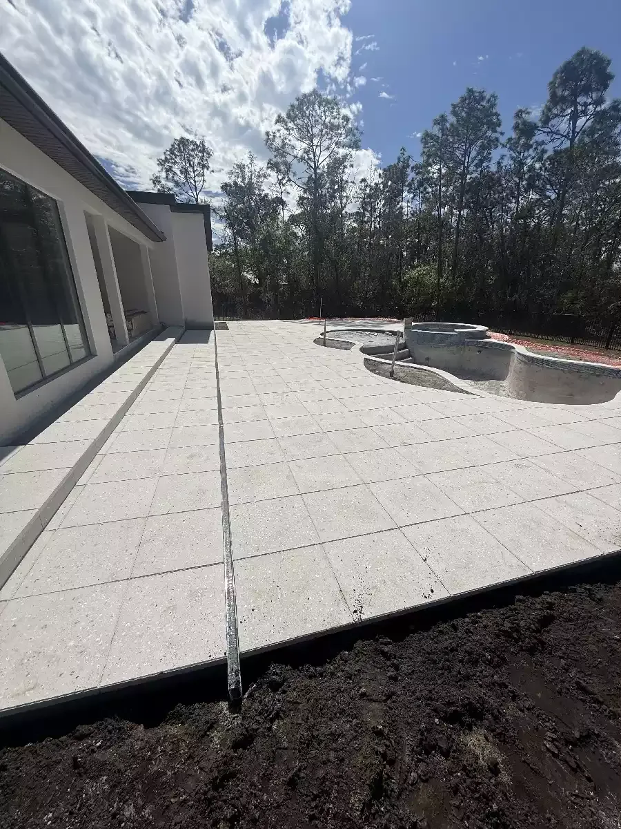 Large format concrete paver pool deck behind a residential home in Venice, Florida