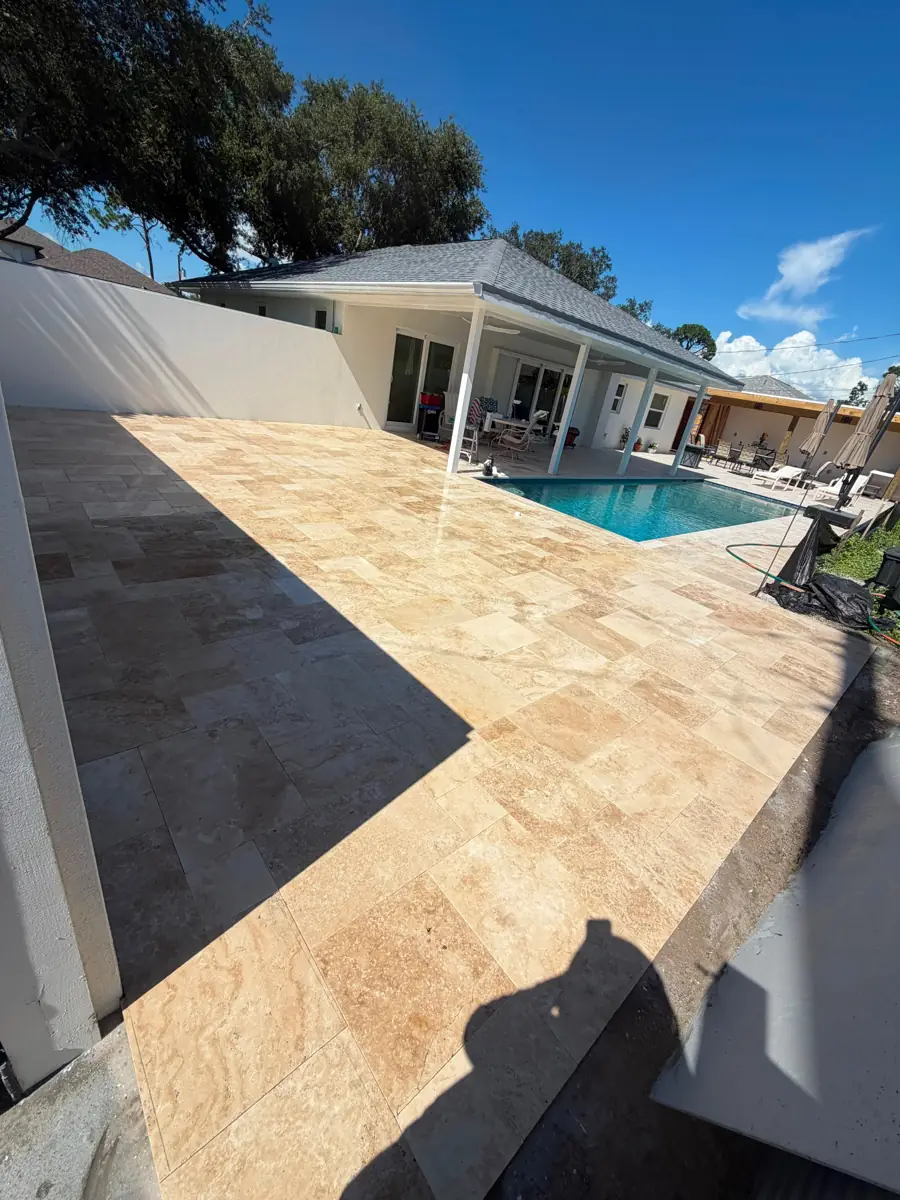 Ivory travertine pool deck surrounding a backyard pool in Venice, Florida