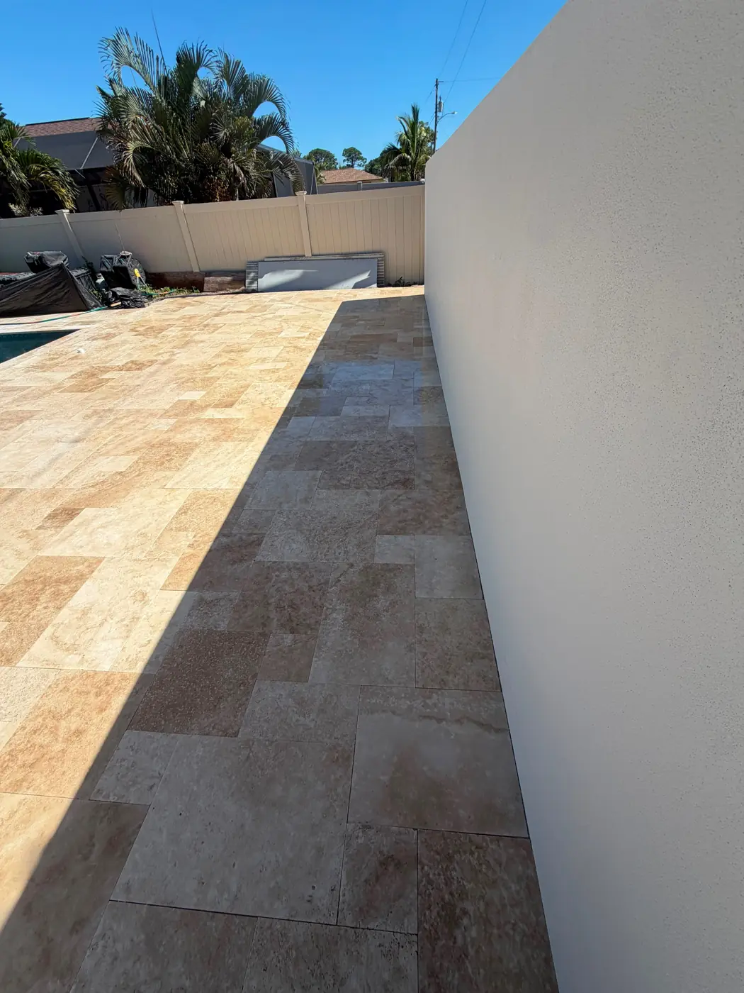 Ivory travertine walkway beside a residential pool deck in Venice, Florida