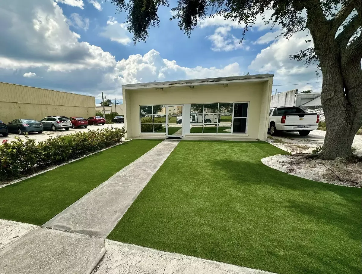 Commercial building entrance with artificial turf lawn and concrete walkway on Venice Island, Florida